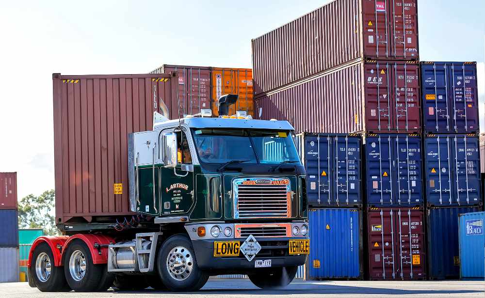 L.Arthur Transport truck carrying a shipping container at a container yard