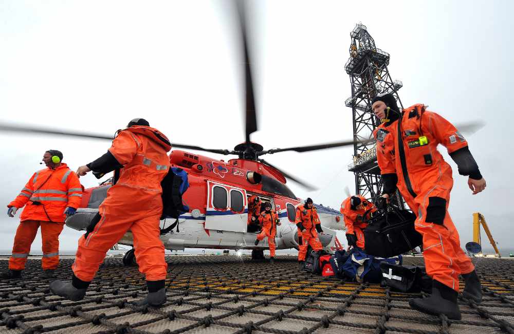 Remote medical response team beside a helicopter on an offshore platform